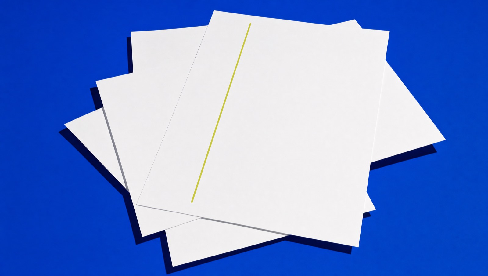 Chalk-white sheets on cobalt, one bearing a chartreuse line